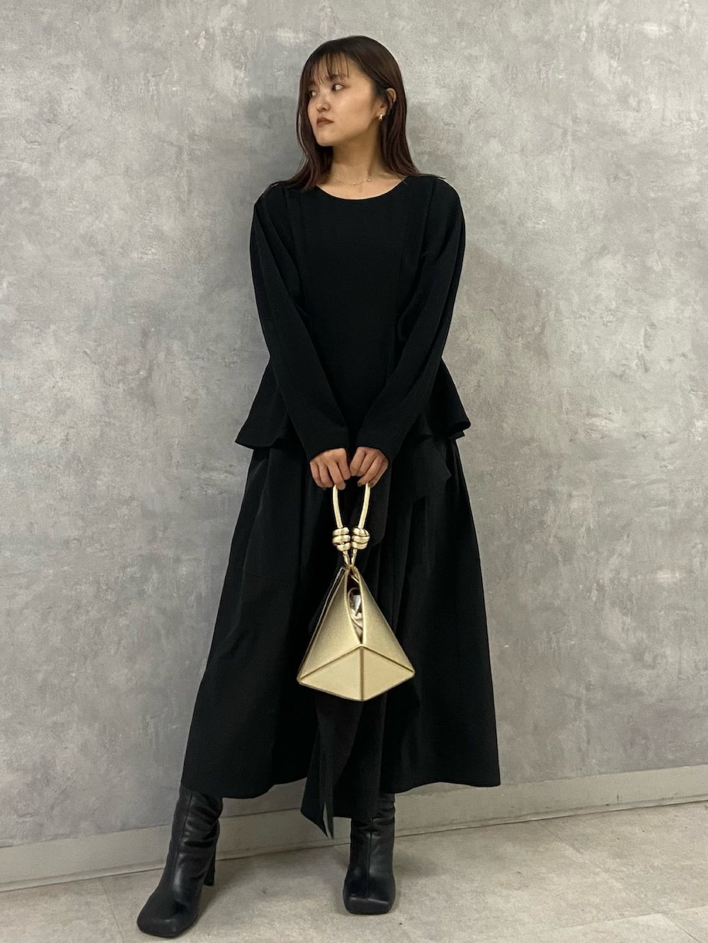 ホワイト系のブルゾン、ブラック系のワンピース、ブラック系のブーツを着用したレディースの冬コーディネートの6枚目の写真