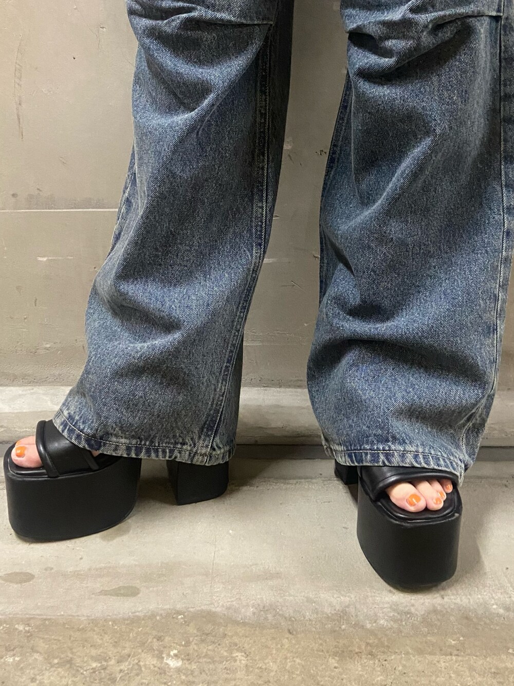 ブラック系のTシャツ/カットソー、ブルー系のデニムパンツ、ブラック系のサンダルを着用したレディースの夏コーディネートの6枚目の写真