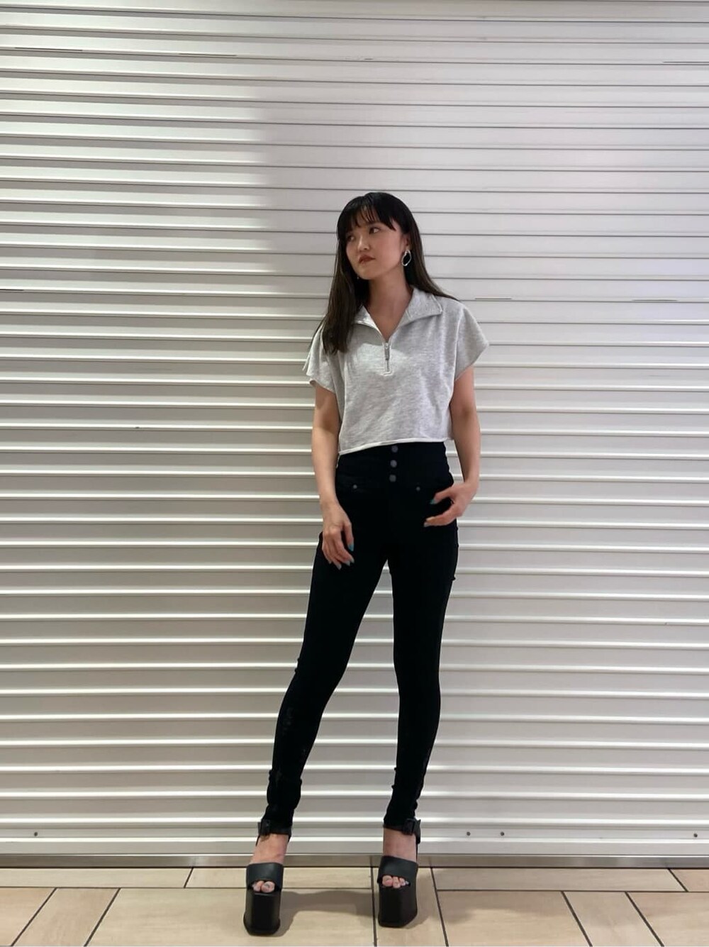 ブラック系のサンダル、ブラック系のデニムパンツ、グレー系のTシャツ/カットソーを着用したレディースの夏コーディネートの2枚目の写真