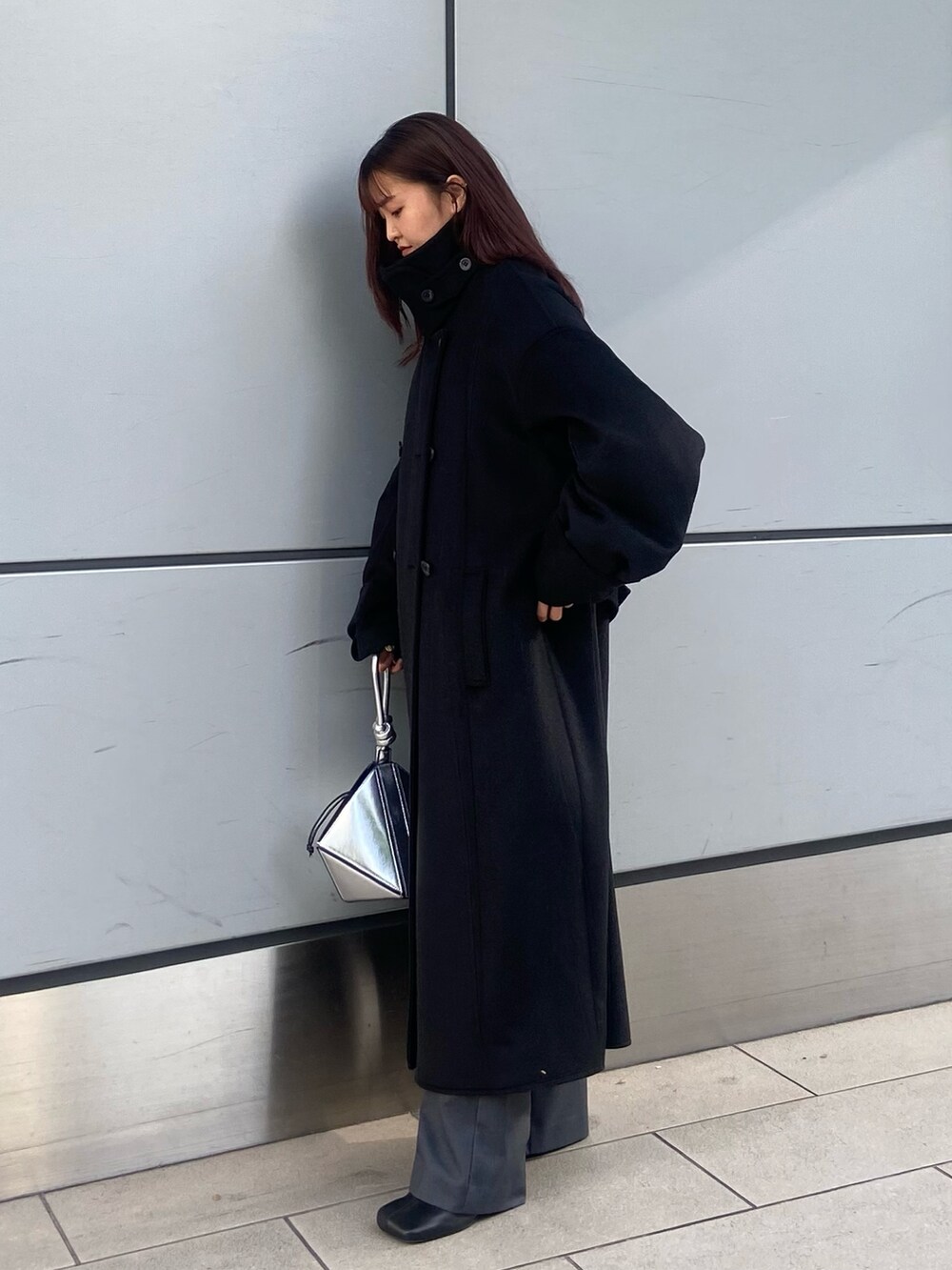 ブラック系のその他アウター、グレー系のその他パンツ、ブラック系のブーツを着用したレディースの冬コーディネートの2枚目の写真