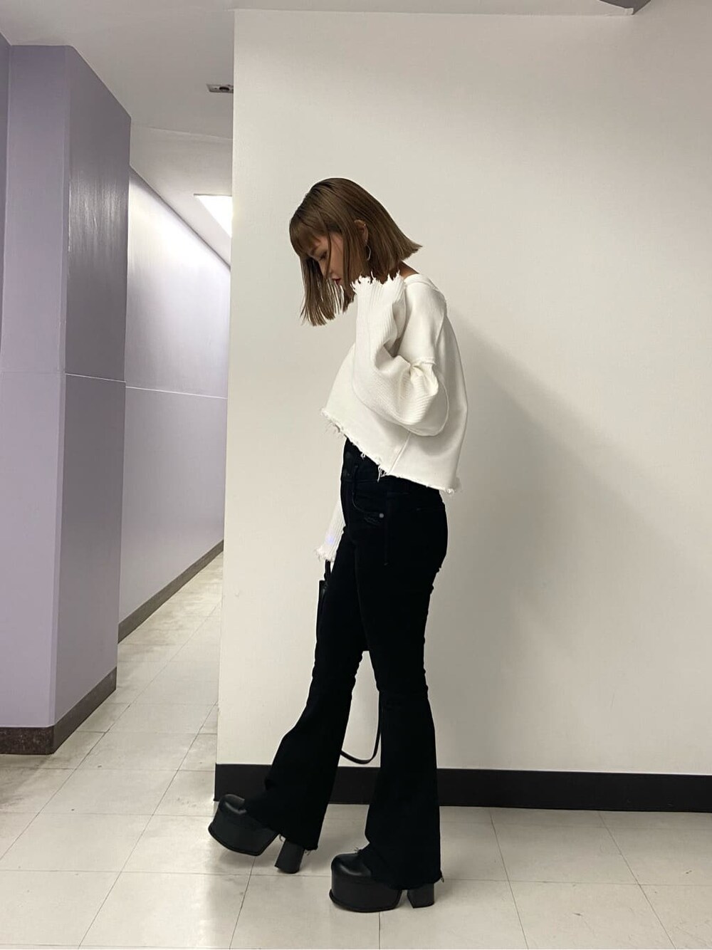 ブラック系のブーツ、ブラック系のハンドバッグ、ホワイト系のカーディガン/ボレロを着用したレディースの秋コーディネートの3枚目の写真