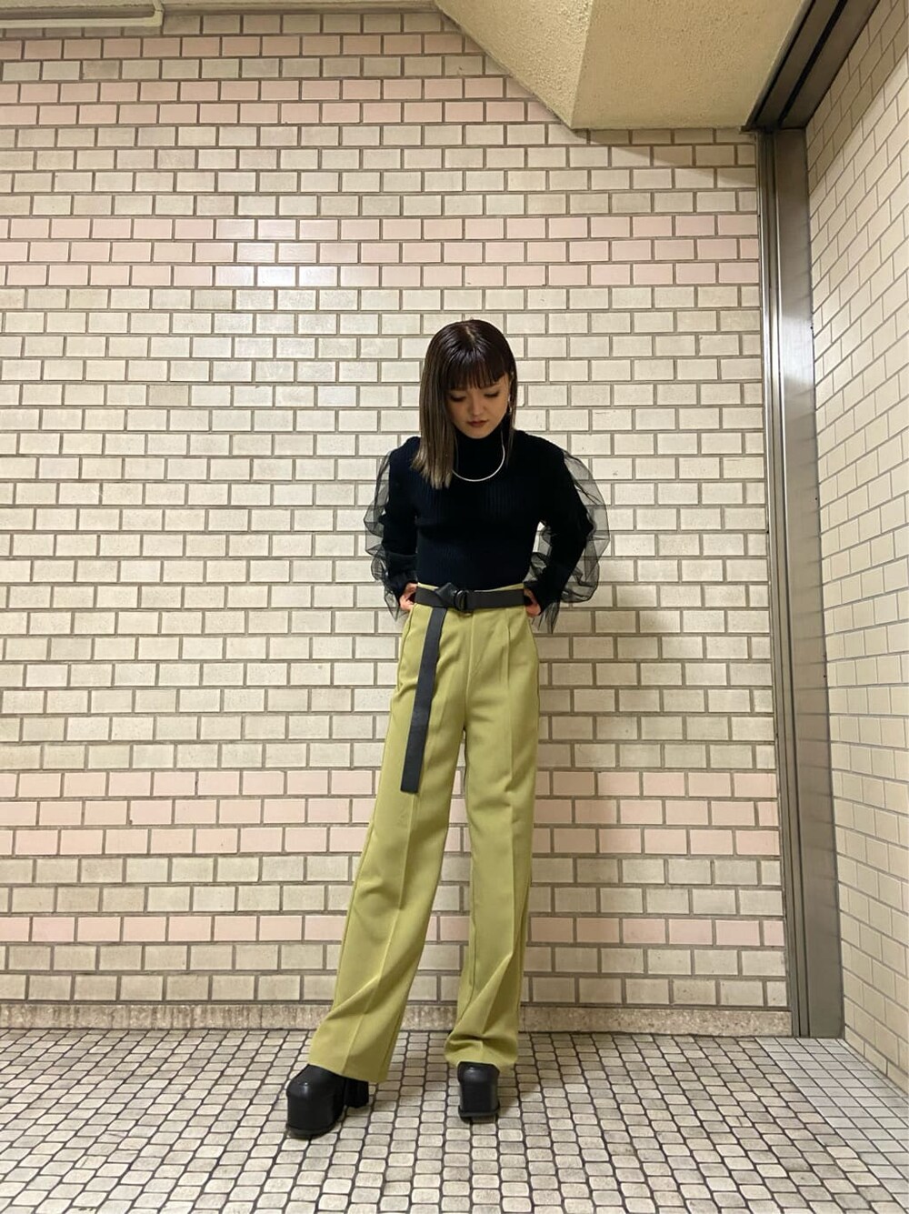 イエロー系のその他パンツ、ブラック系のローファー、ブラック系のニット/セーターを着用したレディースの秋コーディネートの4枚目の写真