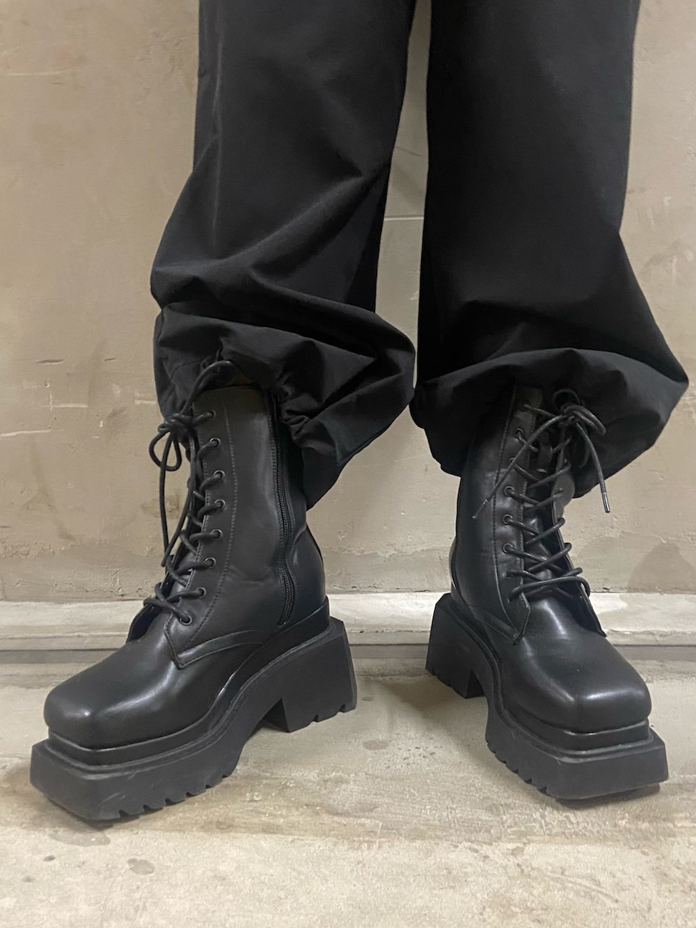 グレー系のニット/セーター、ブラック系のその他パンツ、ブラック系のブーツを着用したレディースの冬コーディネートの5枚目の写真