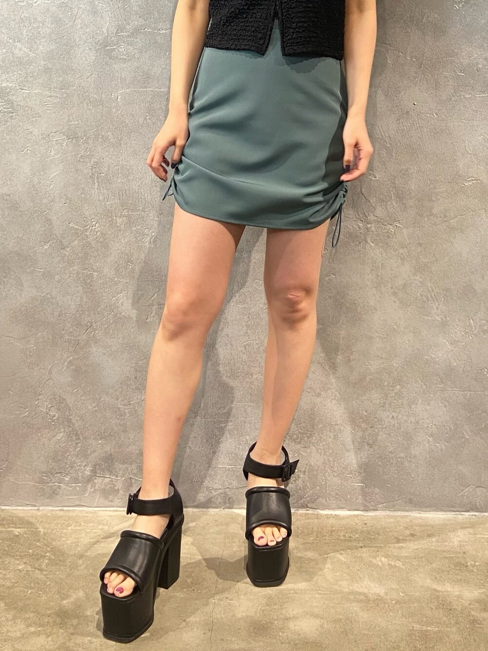 ブラック系のシャツ/ブラウス、グリーン系のスカート、ブラック系のサンダルを着用したレディースの春コーディネートの6枚目の写真