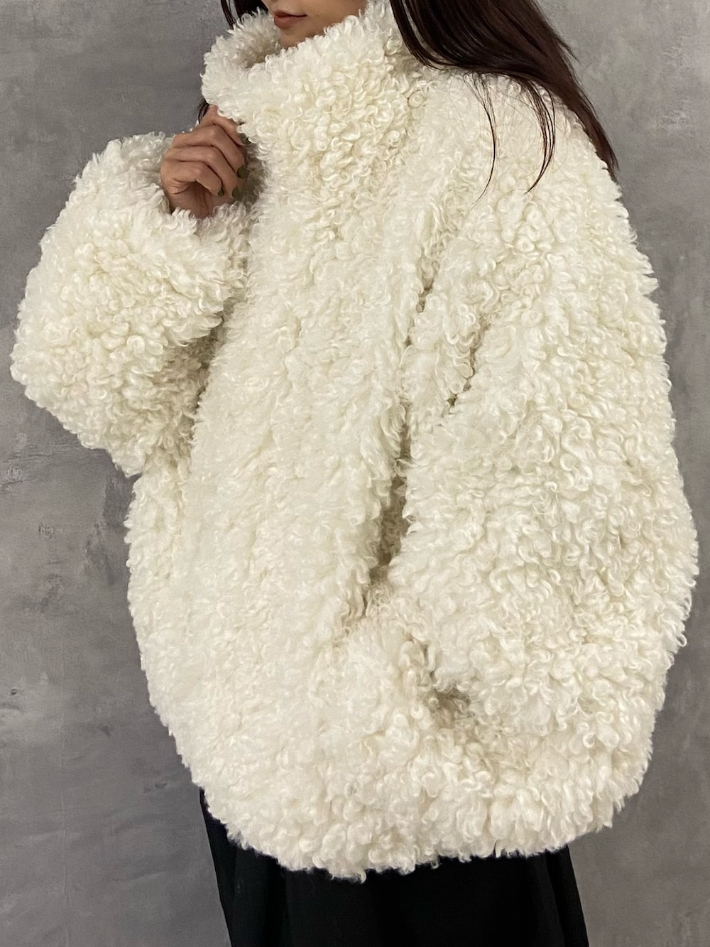 ホワイト系のブルゾン、ブラック系のワンピース、ブラック系のブーツを着用したレディースの冬コーディネートの5枚目の写真