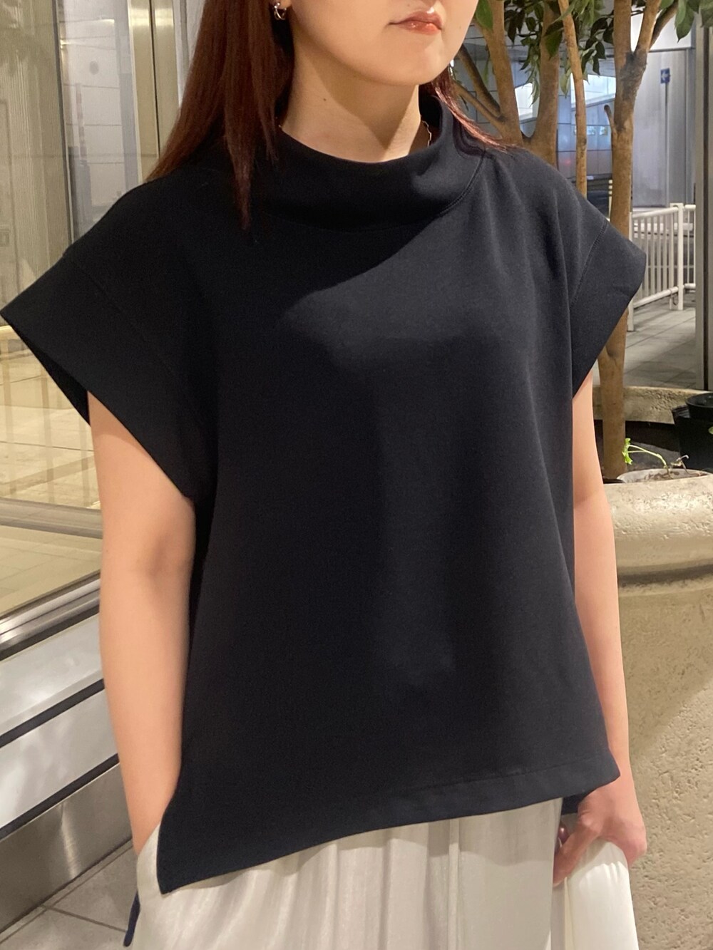 ブラック系のTシャツ/カットソー、ベージュ系のスカート、ホワイト系のサンダルを着用したレディースの春コーディネートの4枚目の写真