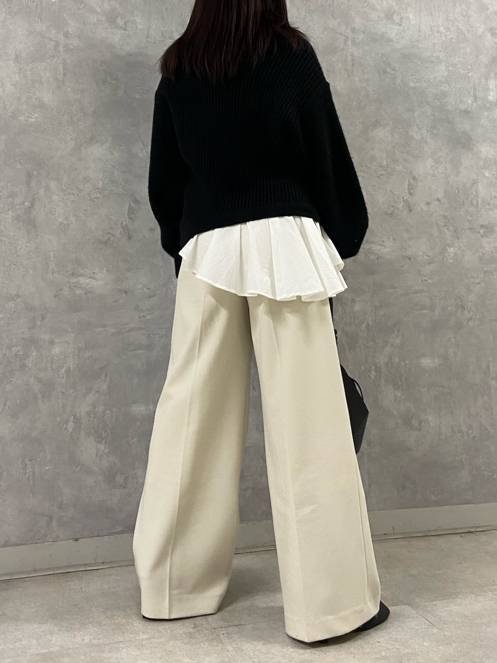 ブラック系のニット/セーター、ホワイト系のその他パンツ、ブラック系のブーツを着用したレディースの冬コーディネートの3枚目の写真