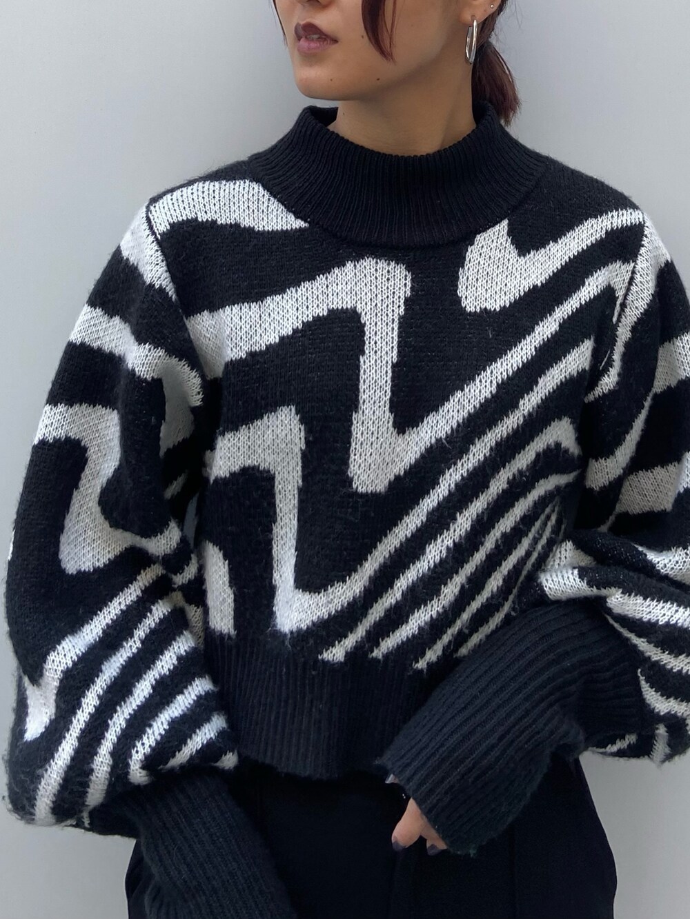 ブラック系のニット/セーター、ブラック系のカーゴパンツ、ブラック系のブーツを着用したレディースの冬コーディネートの4枚目の写真