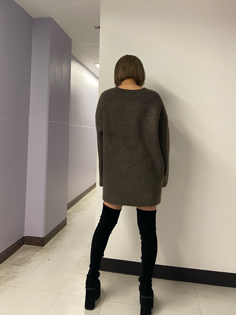 ブラウン系のニット/セーター、ブラック系のスカート、ブラック系のブーツを着用したレディースの冬コーディネートの4枚目の写真