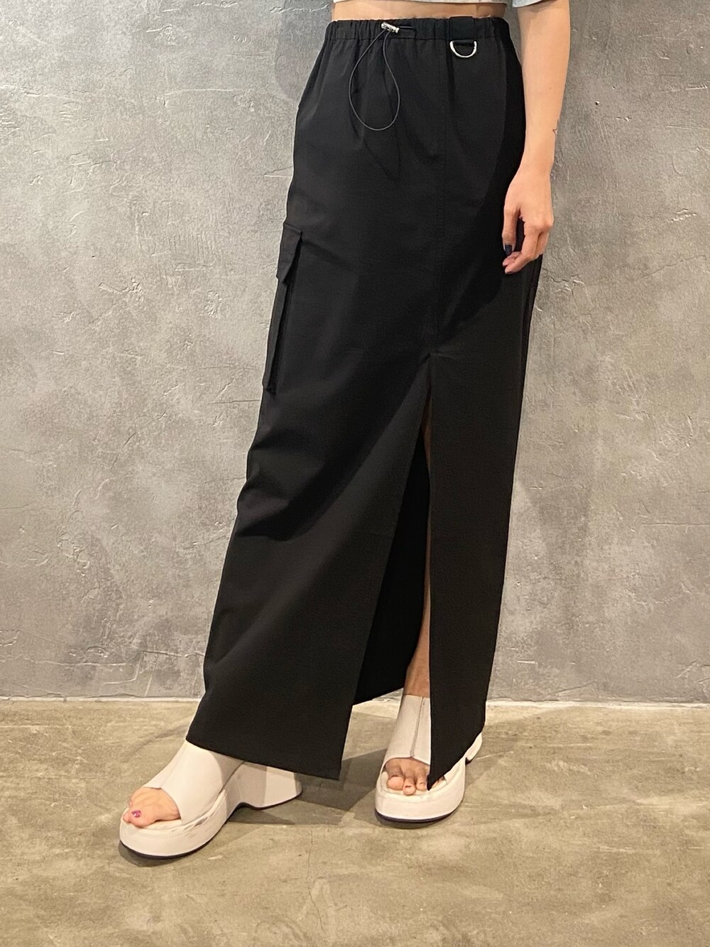 グレー系のTシャツ/カットソー、ホワイト系のサンダル、ブラック系のスカートを着用したレディースの春コーディネートの6枚目の写真