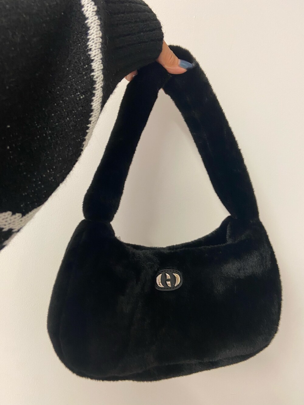 ブラック系のニット/セーター、ベージュ系のスカート、ブラック系のブーツを着用したレディースの秋コーディネートの8枚目の写真