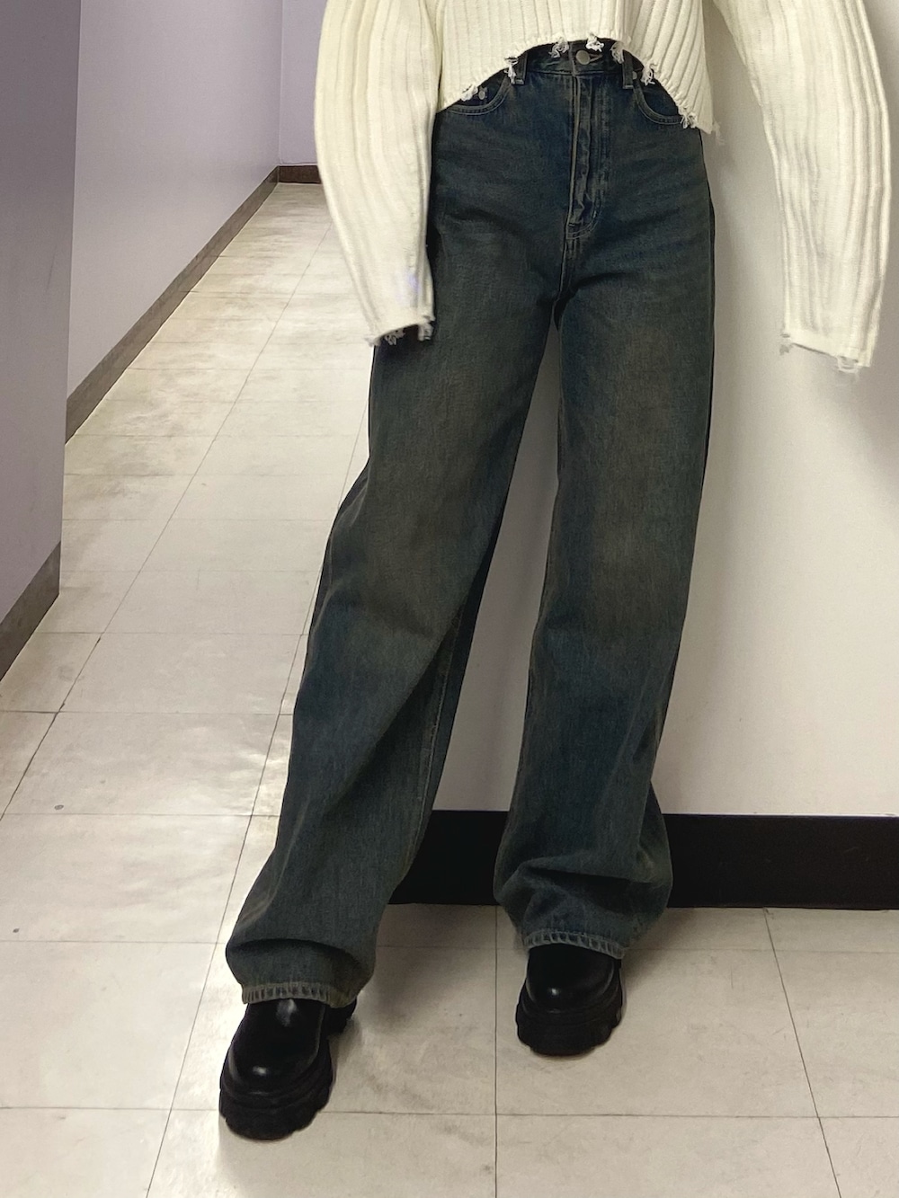ホワイト系のニット/セーター、ブルー系のデニムパンツ、ブラック系のブーツを着用したレディースの秋コーディネートの5枚目の写真