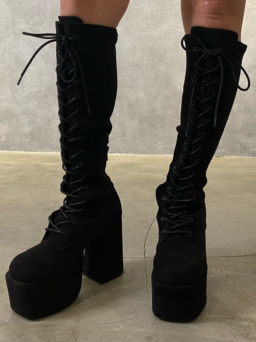 ブラック系のベスト、ホワイト系のシャツ/ブラウス、ブラック系のブーツを着用したレディースの冬コーディネートの7枚目の写真