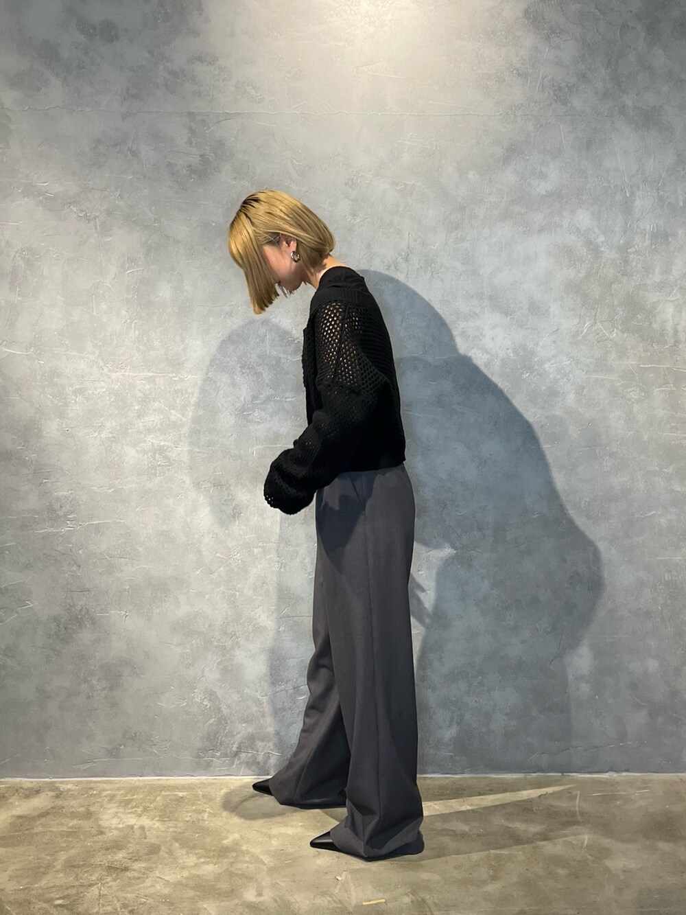 ブラック系のパンプス、グレー系のその他パンツ、ブラック系のニット/セーターを着用したレディースの春コーディネートの3枚目の写真