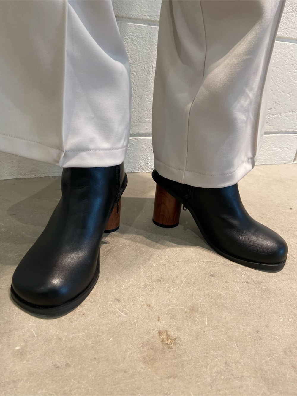 ホワイト系のその他パンツ、ブラック系のブーツ、ブラック系のTシャツ/カットソーを着用したレディースの春コーディネートの7枚目の写真