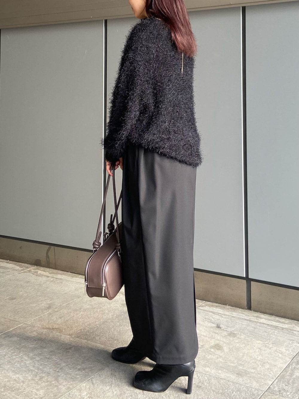 ブラック系のスカート、ブラウン系のボストンバッグ、ブラック系のブーツを着用したレディースの冬コーディネートの6枚目の写真