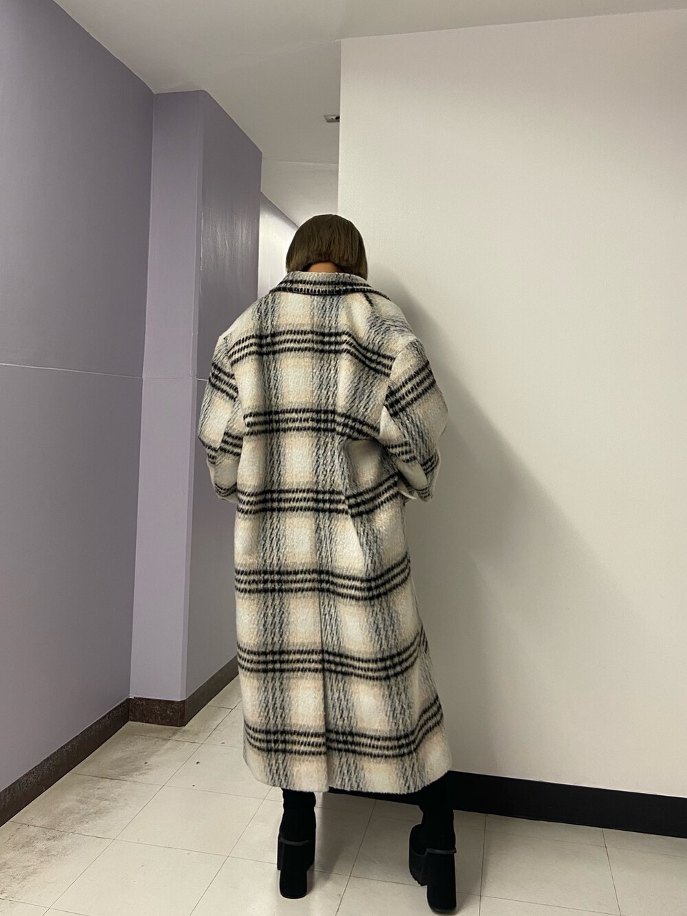 ブラック系のブーツ、ブラック系のスカート、その他のチェスターコートを着用したレディースの冬コーディネートの4枚目の写真