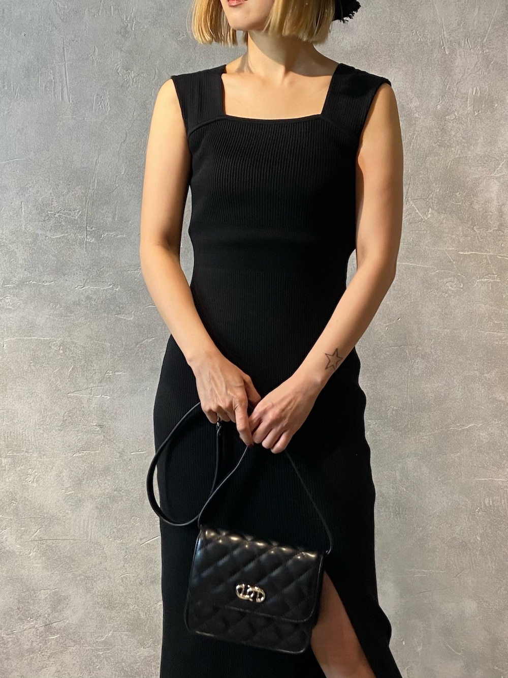 ブラック系のワンピース、ブラック系のショルダーバッグ、ホワイト系のサンダルを着用したレディースの春コーディネートの4枚目の写真