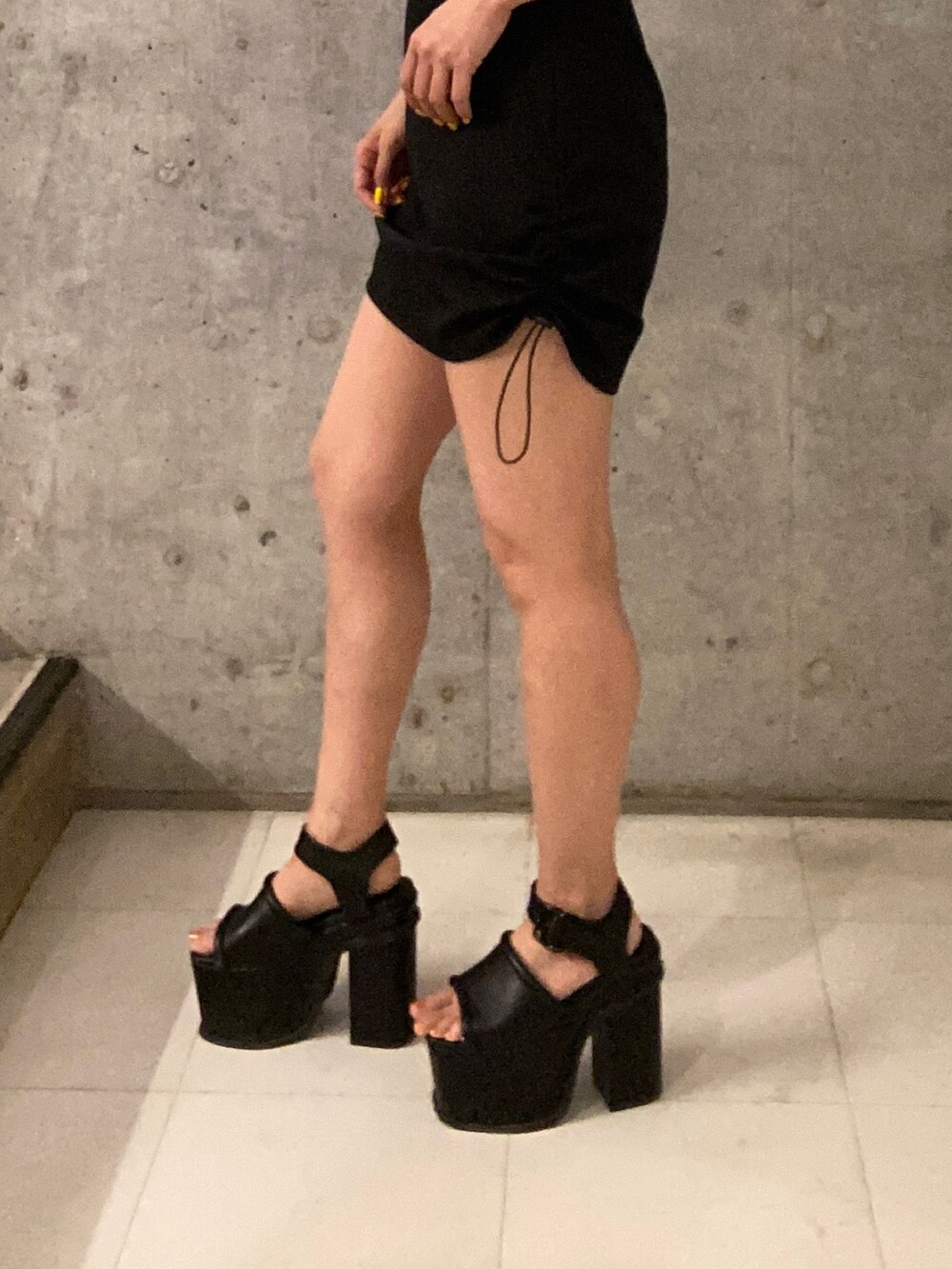 ブルー系のタンクトップ、ブラック系のスカート、ブラック系のサンダルを着用したレディースの春コーディネートの6枚目の写真