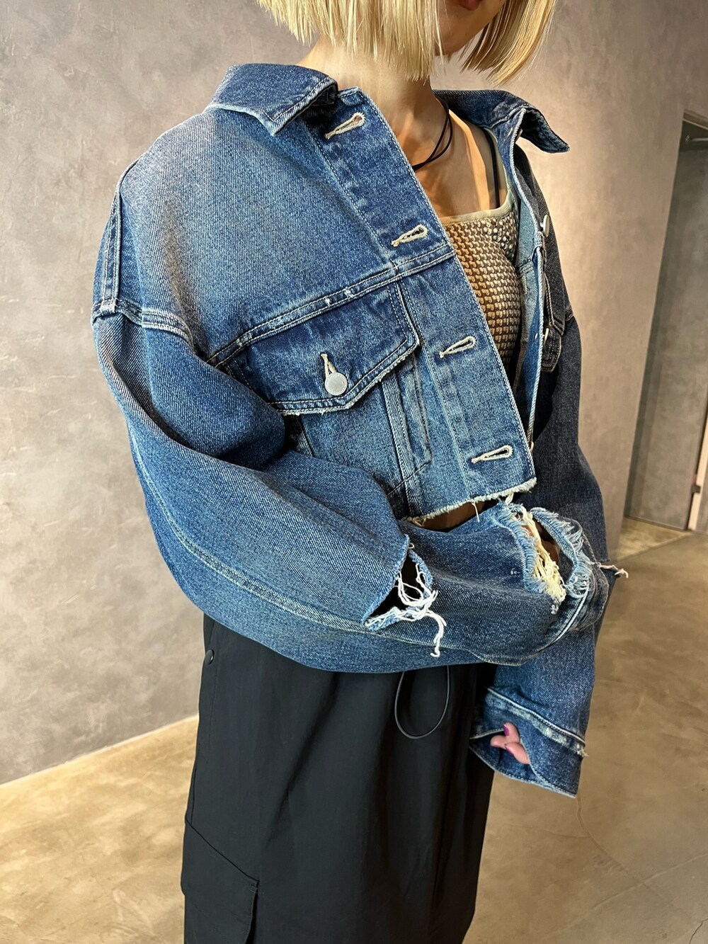 ブルー系のデニムジャケット、ベージュ系のキャミソール、ブラック系のスカートを着用したレディースの春コーディネートの5枚目の写真