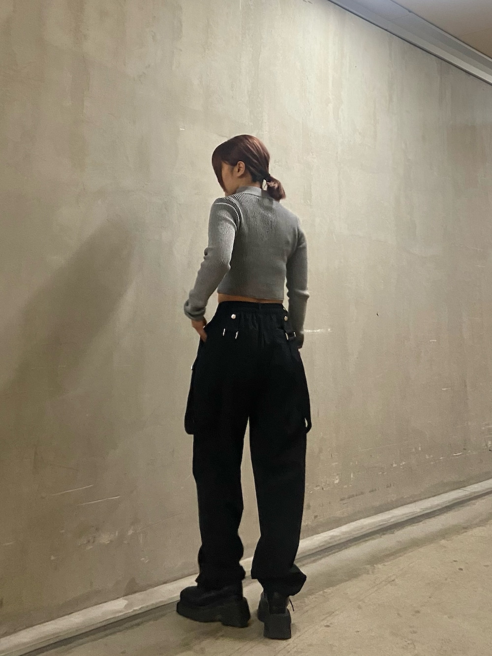 グレー系のニット/セーター、ブラック系のその他パンツ、ブラック系のブーツを着用したレディースの冬コーディネートの2枚目の写真