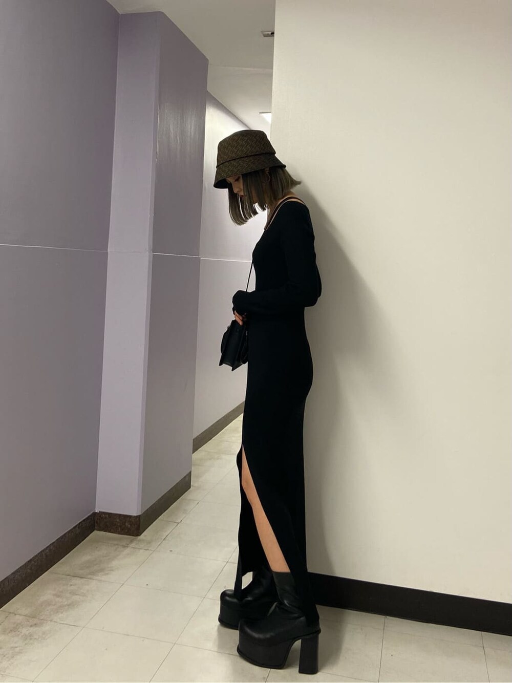 ブラック系のワンピース、ブラック系のブーツ、ブラック系のハンドバッグを着用したレディースの秋コーディネートの3枚目の写真