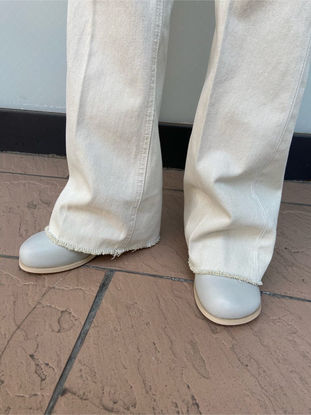 ホワイト系のデニムジャケット、グレー系のブーツ、その他のTシャツ/カットソーを着用したレディースの春コーディネートの8枚目の写真