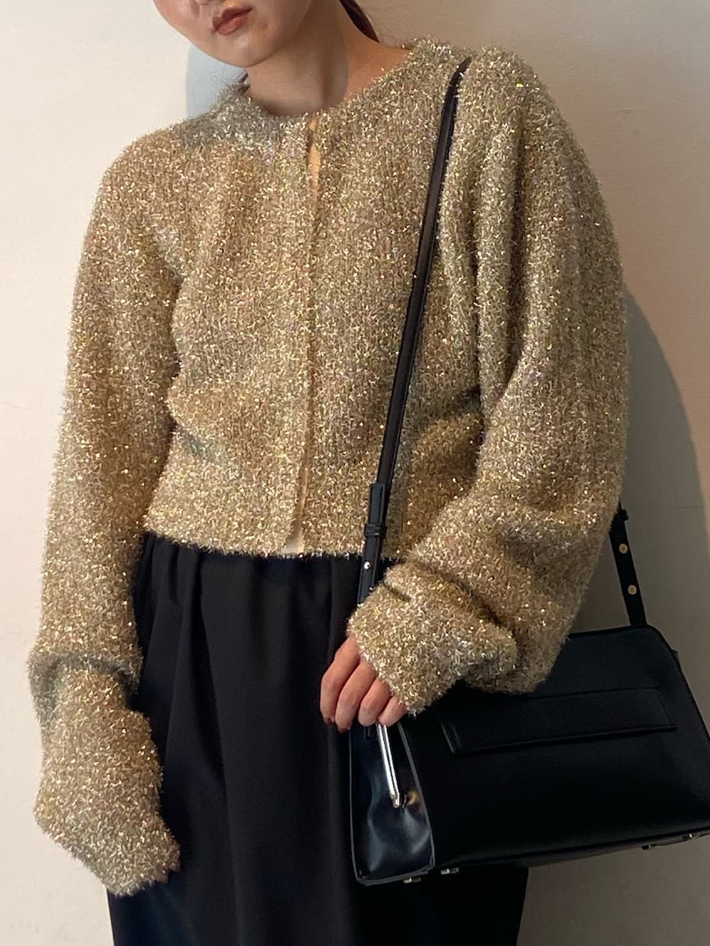 ゴールド系のカーディガン/ボレロ、ブラック系のスカート、ブラック系のサンダルを着用したレディースの冬コーディネートの4枚目の写真