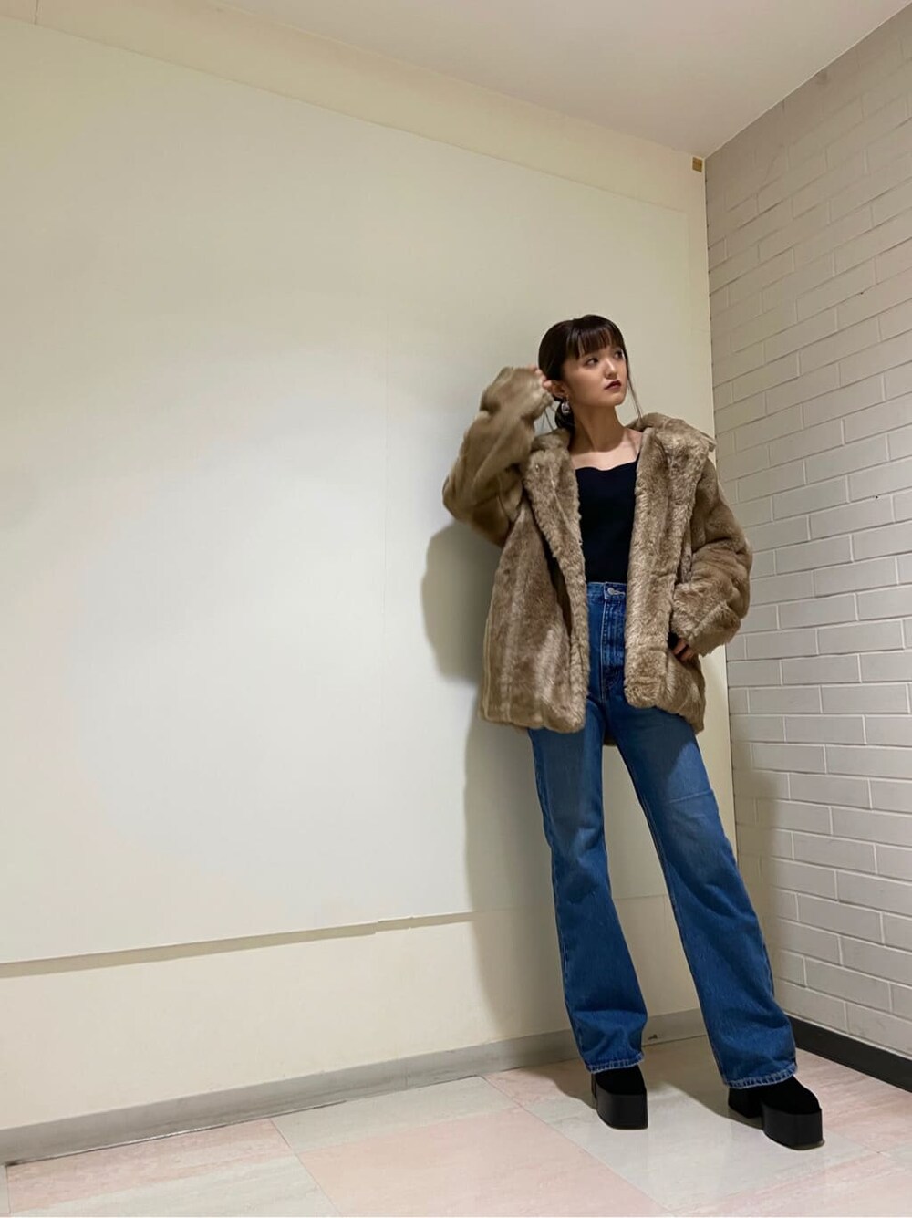 ブルー系のデニムパンツ、ブラック系のブーツ、ベージュ系のその他アウターを着用したレディースの冬コーディネートの6枚目の写真