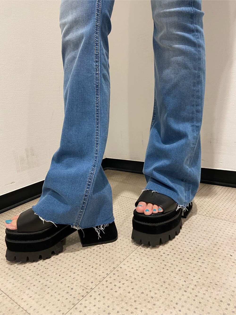 ブルー系のデニムパンツ、ブラック系のサンダル、ブラック系のTシャツ/カットソーを着用したレディースの夏コーディネートの7枚目の写真