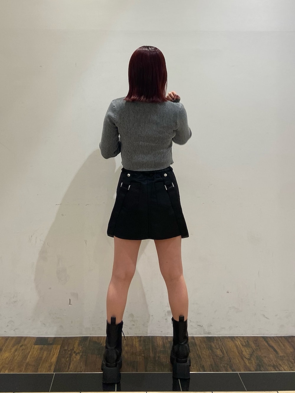 グレー系のニット/セーター、その他のスカート、ブラック系のブーツを着用したレディースの冬コーディネートの2枚目の写真