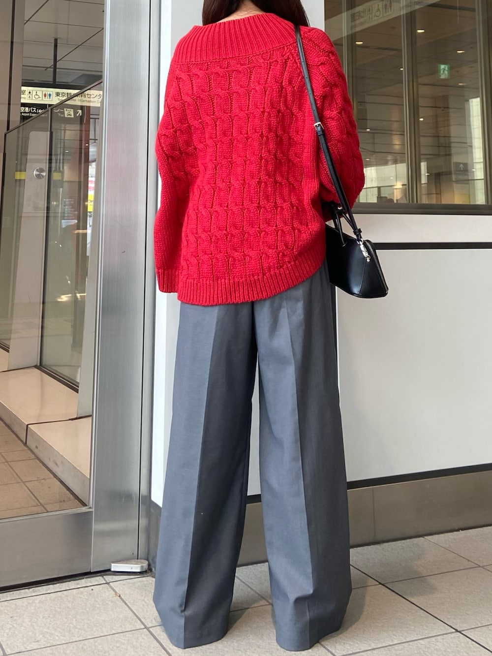 レッド系のニット/セーター、グレー系のその他パンツ、ホワイト系のパンプスを着用したレディースの冬コーディネートの3枚目の写真