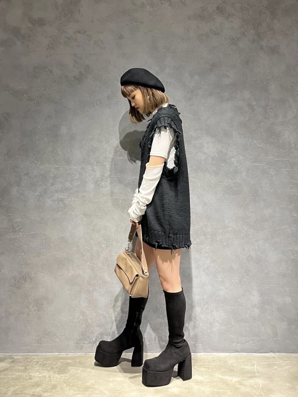 ホワイト系のTシャツ/カットソー、ブラウン系のハンドバッグ、ブラック系のスカートを着用したレディースの秋コーディネートの2枚目の写真