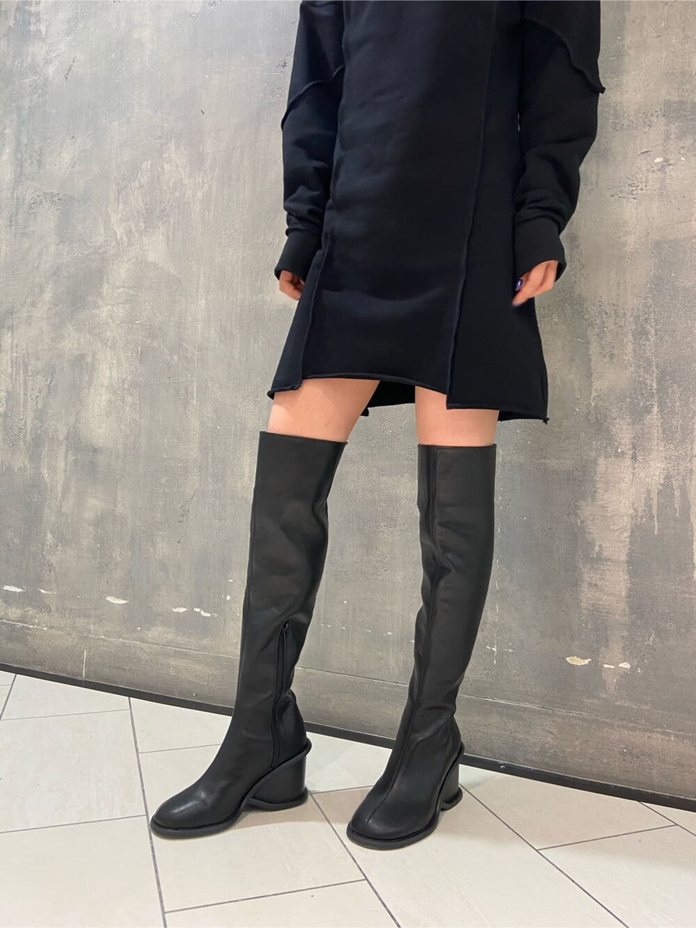 ブラック系のワンピース、ブラック系のブーツ、グリーン系のボディバッグ/ウエストポーチを着用したレディースの秋コーディネートの4枚目の写真