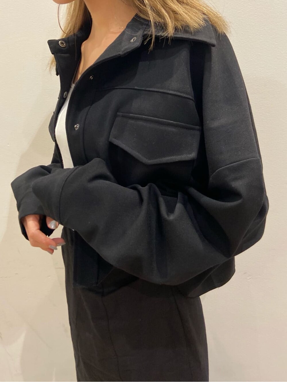 ブラック系のブルゾン、ホワイト系のサンダル、ブラック系のスカートを着用したレディースの春コーディネートの5枚目の写真