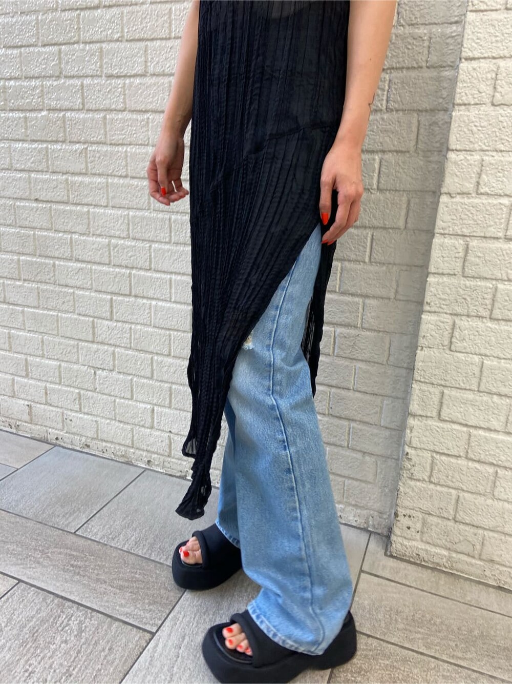 ホワイト系のタンクトップ、ブルー系のデニムパンツ、ブラック系のワンピースを着用したレディースの夏コーディネートの5枚目の写真