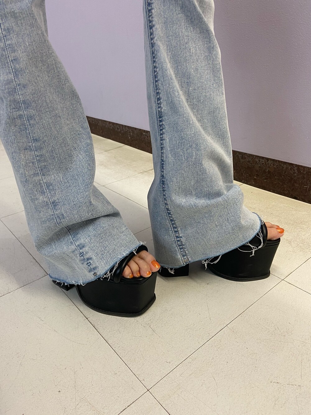 ブラック系のTシャツ/カットソー、ブルー系のデニムパンツ、ブラック系のサンダルを着用したレディースの春コーディネートの7枚目の写真