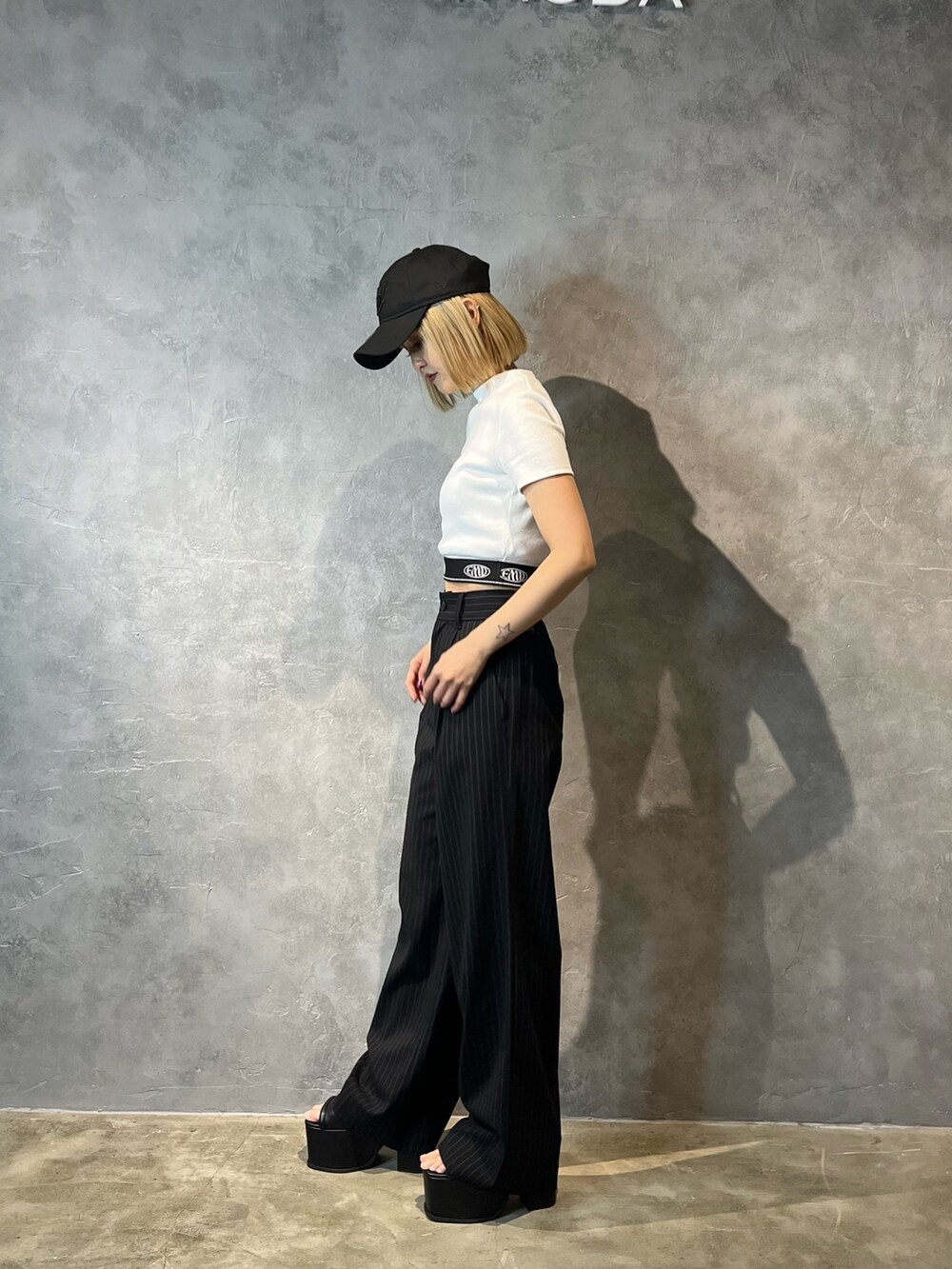 ホワイト系のTシャツ/カットソー、その他のその他パンツ、ブラック系のサンダルを着用したレディースの春コーディネートの2枚目の写真