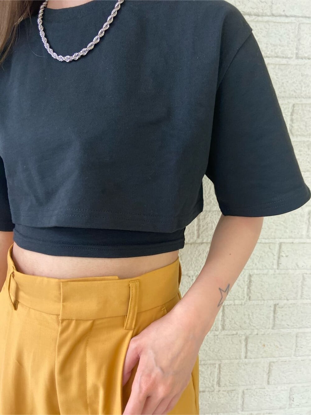 ブラック系のサンダル、オレンジ系のその他パンツ、ブラック系のTシャツ/カットソーを着用したレディースの春コーディネートの5枚目の写真