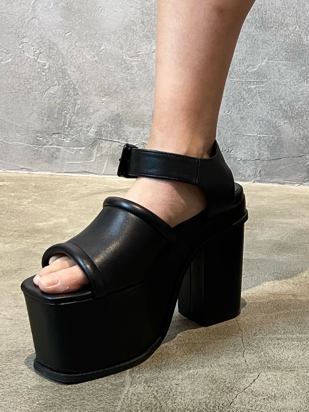 ブラック系のTシャツ/カットソー、ブルー系のデニムパンツ、ブラック系のサンダルを着用したレディースの冬コーディネートの7枚目の写真