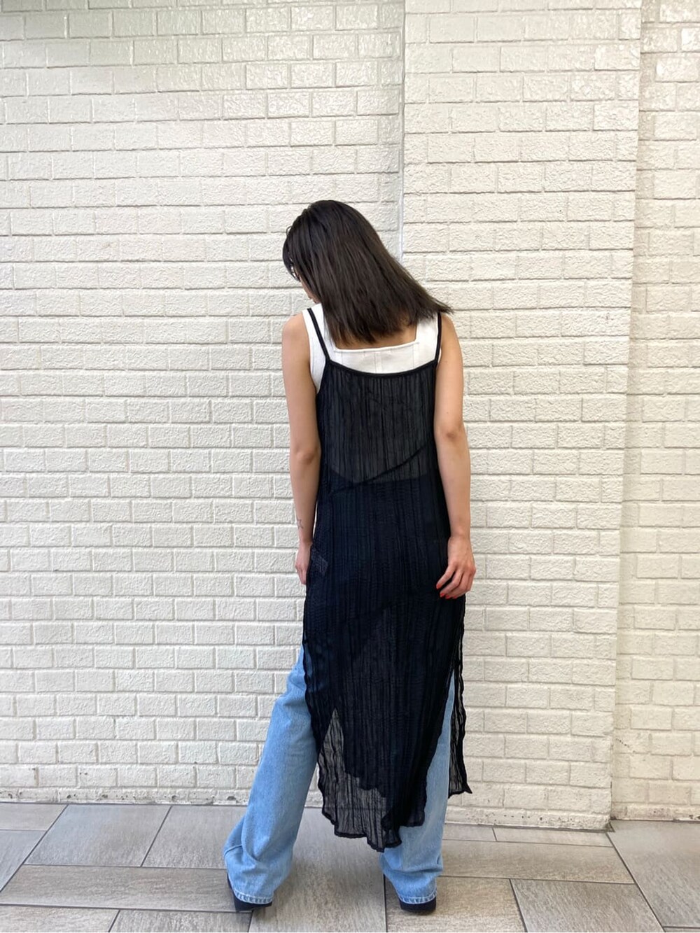 ホワイト系のタンクトップ、ブルー系のデニムパンツ、ブラック系のワンピースを着用したレディースの夏コーディネートの3枚目の写真