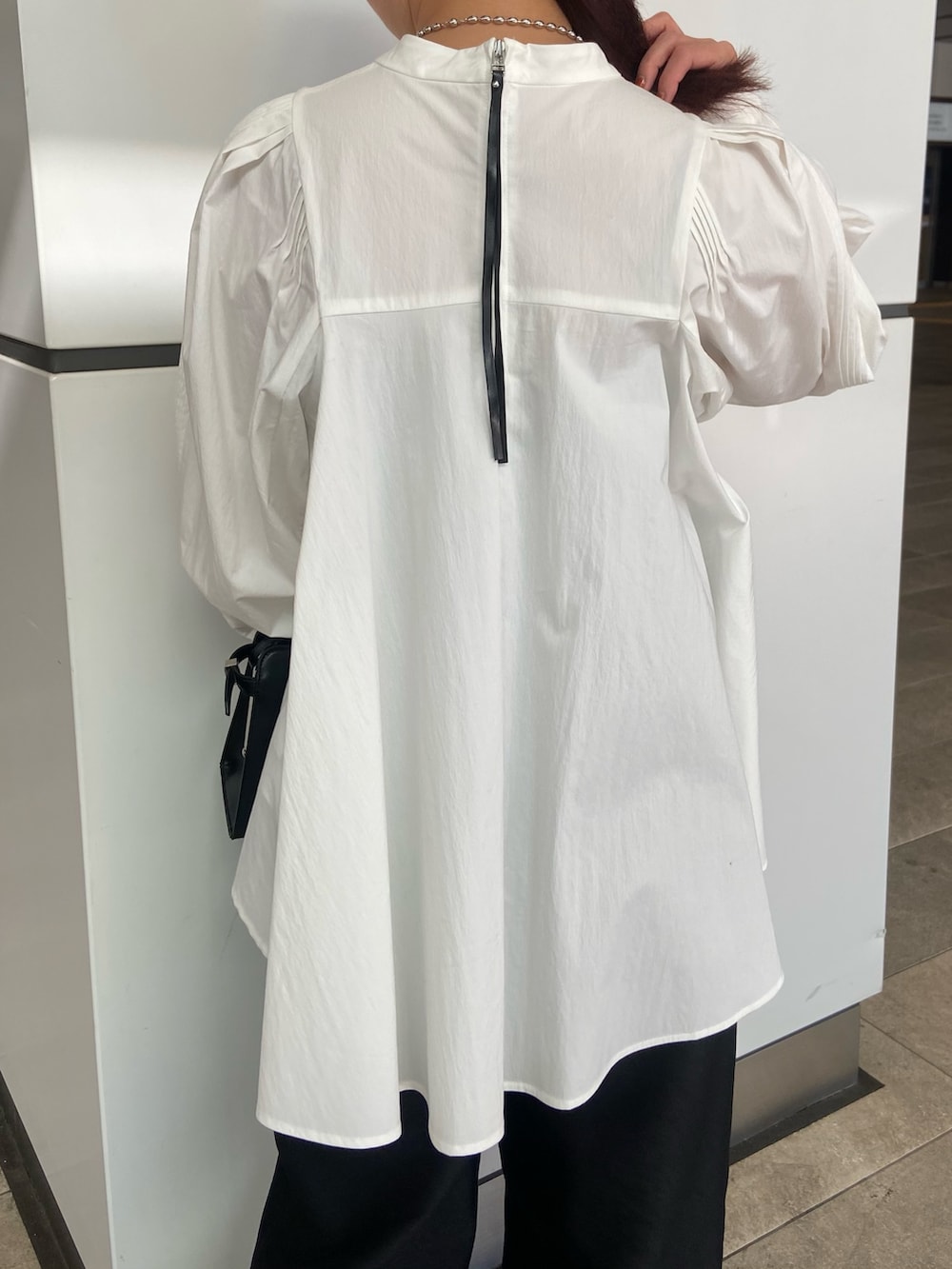 ホワイト系のシャツ/ブラウス、ブラック系のその他パンツ、ブラック系のハンドバッグを着用したレディースの冬コーディネートの6枚目の写真