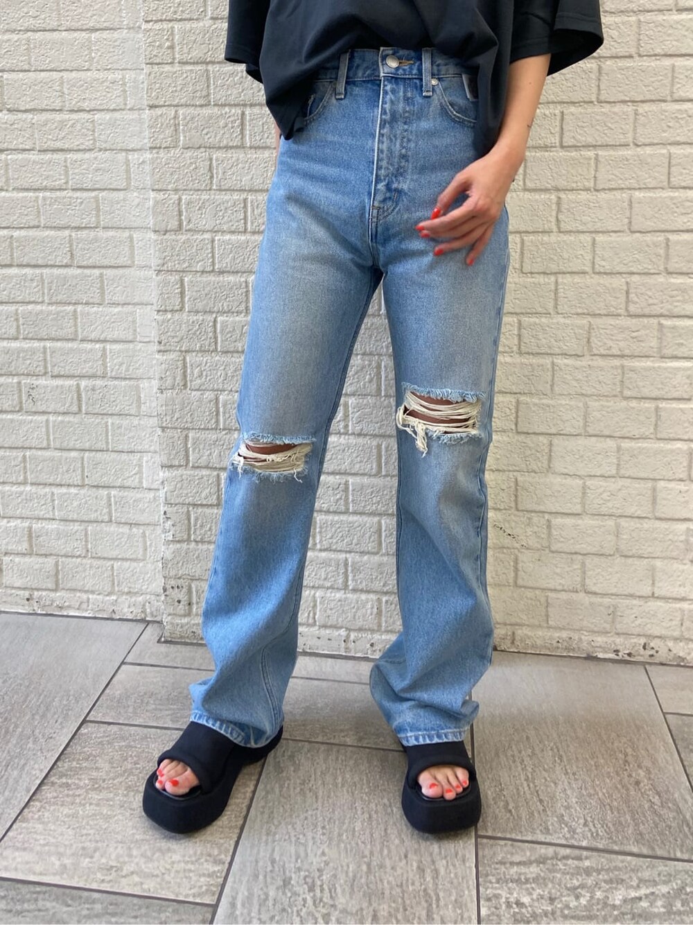 ブルー系のデニムパンツ、ブラック系のTシャツ/カットソー、ブラック系のサンダルを着用したレディースの夏コーディネートの6枚目の写真