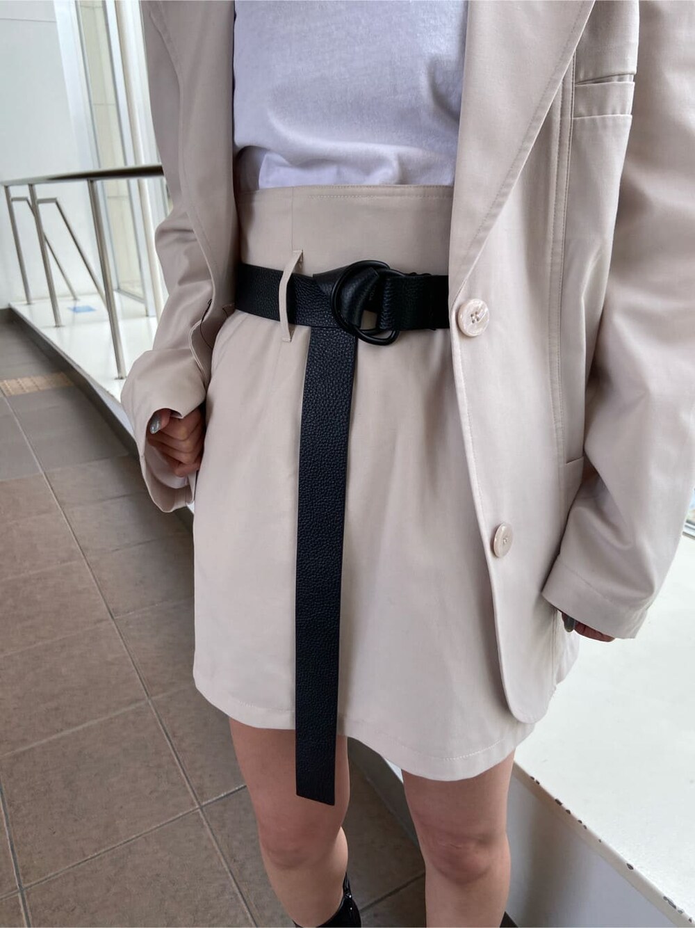 ホワイト系のテーラードジャケット、ブラック系のブーツ、ホワイト系のスカートを着用したレディースの春コーディネートの5枚目の写真