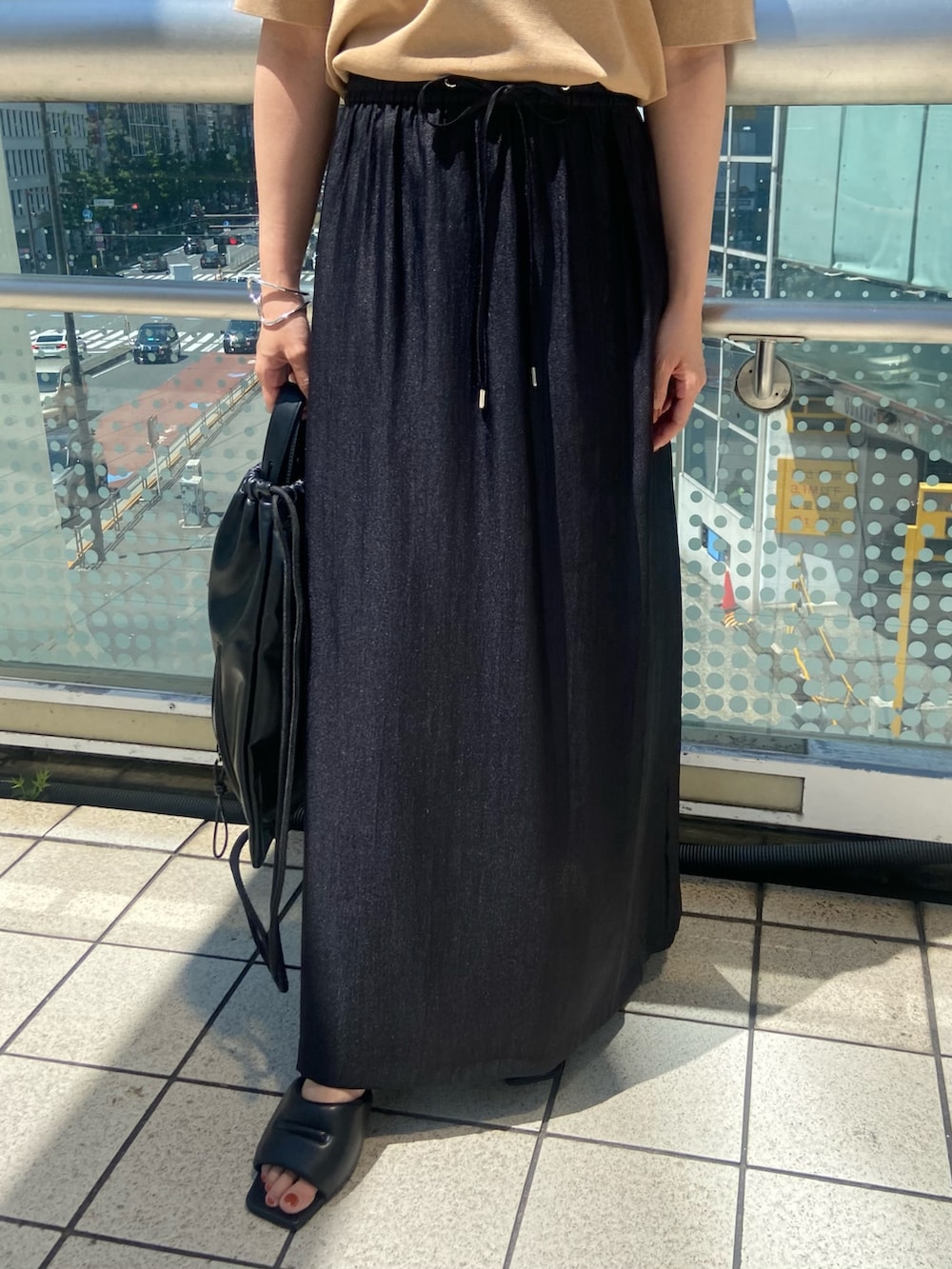 ブラック系のスカート、ブラック系のサンダル、ベージュ系のニット/セーターを着用したレディースの夏コーディネートの6枚目の写真