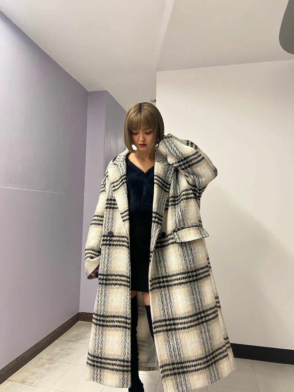 ブラック系のブーツ、ブラック系のスカート、その他のチェスターコートを着用したレディースの冬コーディネートの5枚目の写真