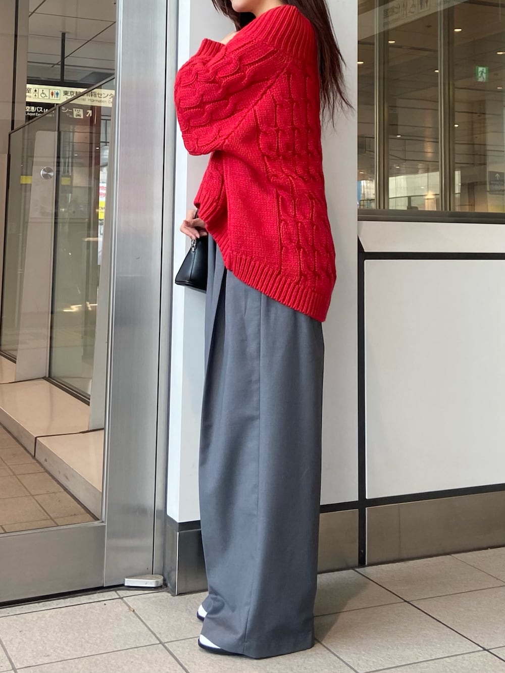 レッド系のニット/セーター、グレー系のその他パンツ、ホワイト系のパンプスを着用したレディースの冬コーディネートの2枚目の写真