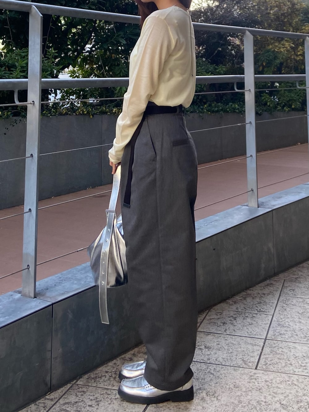 イエロー系のニット/セーター、グレー系のその他パンツ、シルバー系のローファーを着用したレディースの冬コーディネートの2枚目の写真