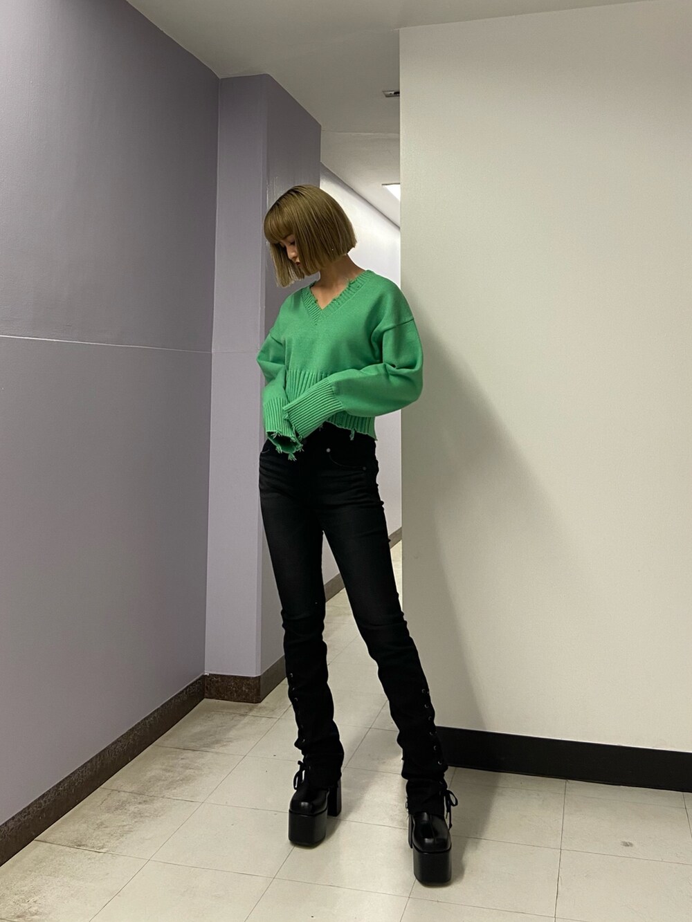 ブラック系のパンツ、グリーン系のニット/セーター、ブラック系のブーツを着用したレディースの冬コーディネートの2枚目の写真