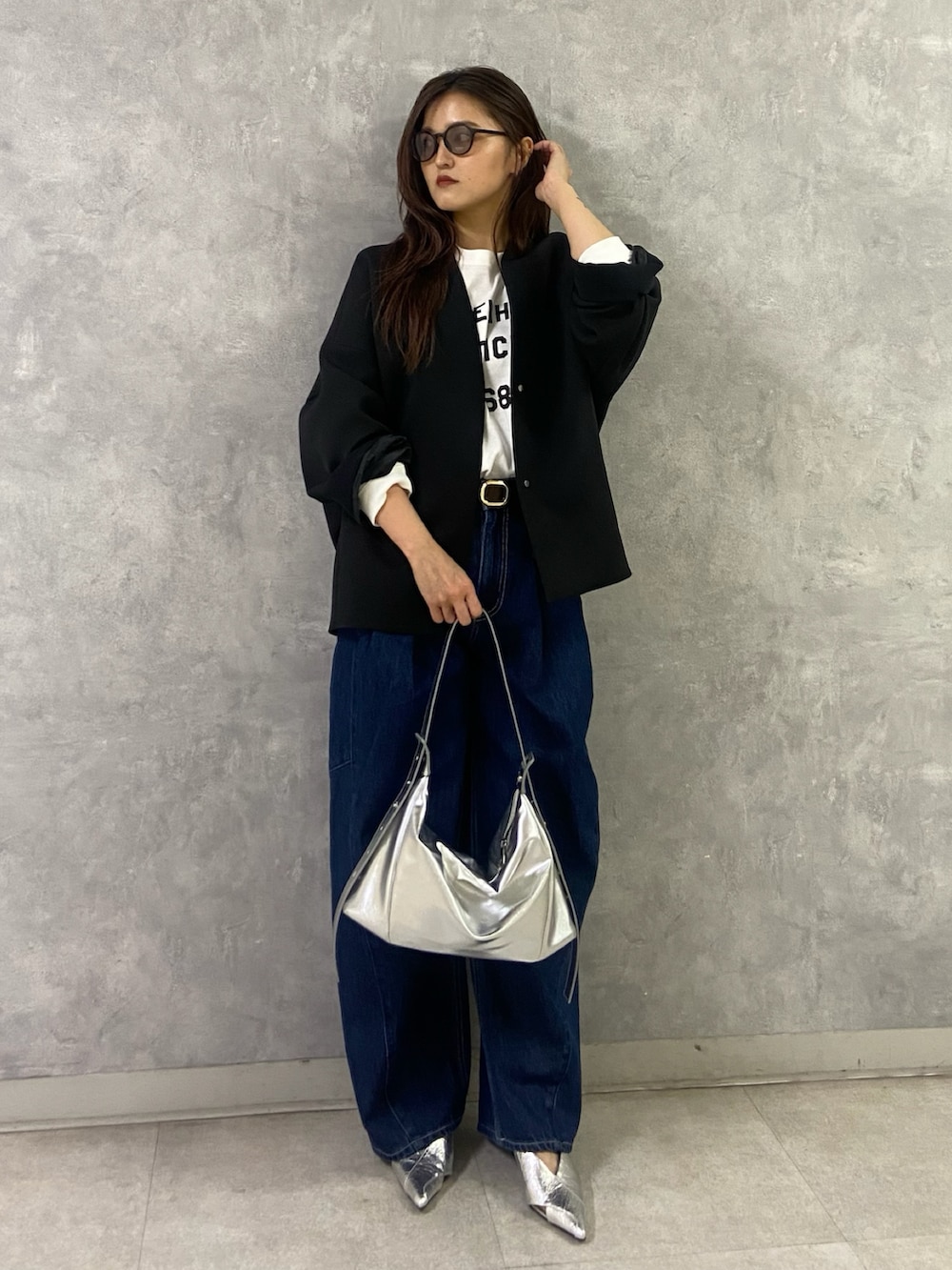 ブラック系のその他アウター、ホワイト系のTシャツ/カットソー、ブルー系のデニムパンツを着用したレディースの冬コーディネートの3枚目の写真